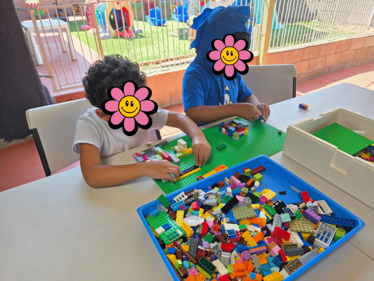 Two kids playing with lego bricks.