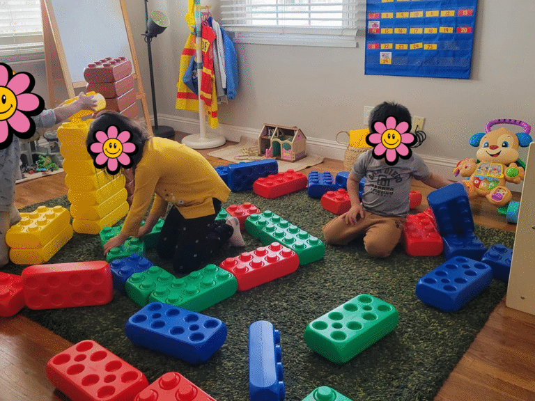 Children playing with large lego bricks inside daycare.